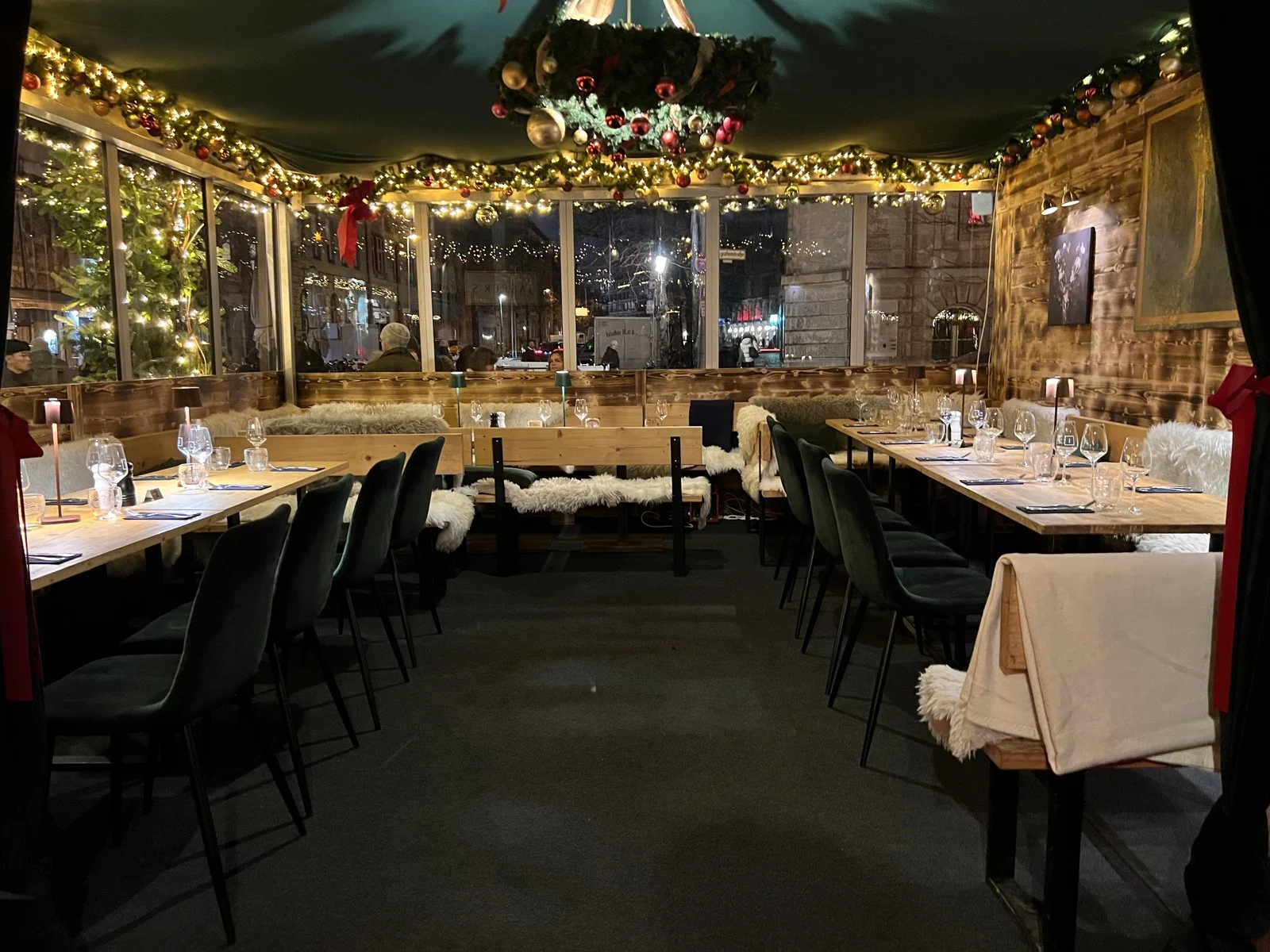 Festlich gedeckte Tische und Lichterketten in Jasper’s Weihnachtsmarkt-Zelt aus der vergangenen Saison